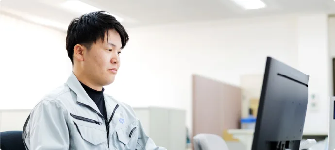 パソコンに向かって設計業務を行う設計職の社員